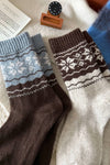 Pair of brown and blue patterned socks on a textured surface.